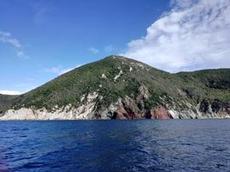 Rostfärgade berg längs insegling till Portoferrario